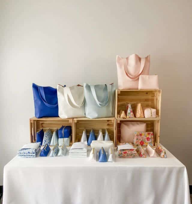 Stuffing tote bags in a craft show display